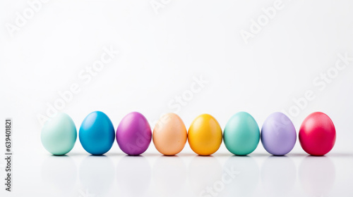 Row of colorful easter eggs on white copysapce background. Chocolate candy in studio