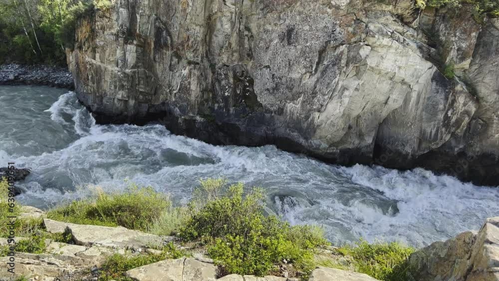 Mountain river in the wild. A powerful stream of water flowing through stone boulders. Beautiful view of the picturesque river and mountains from above Mountain river in the wild. A powerful stream of water flowing through stone boulders. Beautiful view of the picturesque river and mountains from above