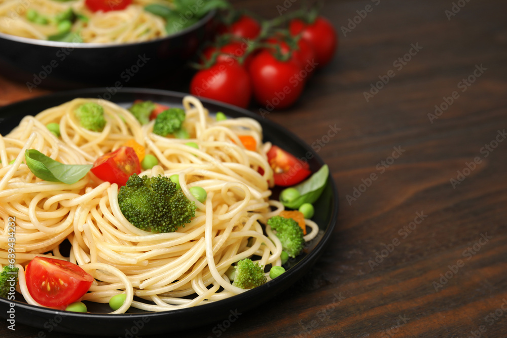 Plate of delicious pasta primavera on wooden table, closeup