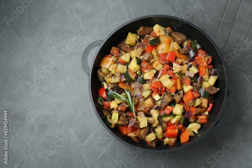 Delicious ratatouille in baking dish on grey table, top view. Space for text