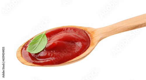 Wooden spoon with tasty ketchup and basil isolated on white