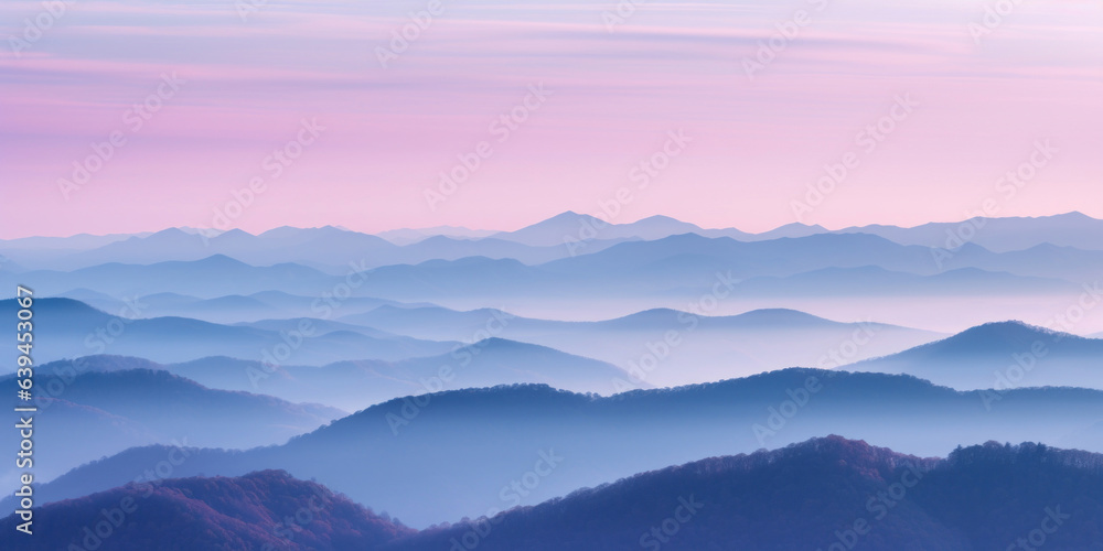 The mountains are shrouded in mist, and the last traces of daylight lend a tranquil, mystical quality to the scene. A twilight shot of autumn mountains under a fading pink and purple sky.