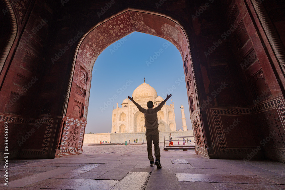 tourist standing in front entrance gate of Taj Mahal indian palace. Islam architecture. Door to the mosque 