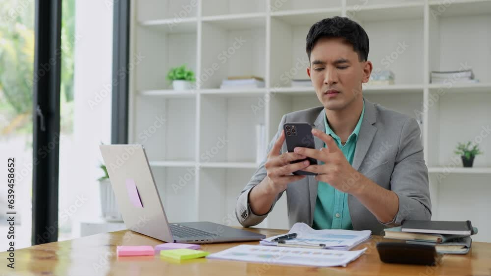 Young Asian businessmen using mobile phones for business communication Using technology to connect advisor clients to discuss digital financial information online. Young Asian businessmen using mobile phones for business communication Using technology to connect advisor clients to discuss digital financial information online.