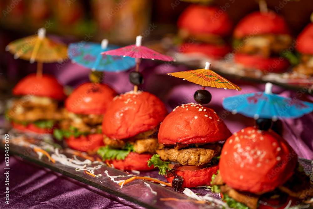 set of small colored burgers. mini burgers. Beautifully decorated catering banquet table with different burgers on a plate on corporate, Christmas, birthday party, event or wedding