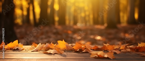  Autum background concept. Golden leaves fall onto a wooden table  with the background being a blurred bokeh autumn nature park.