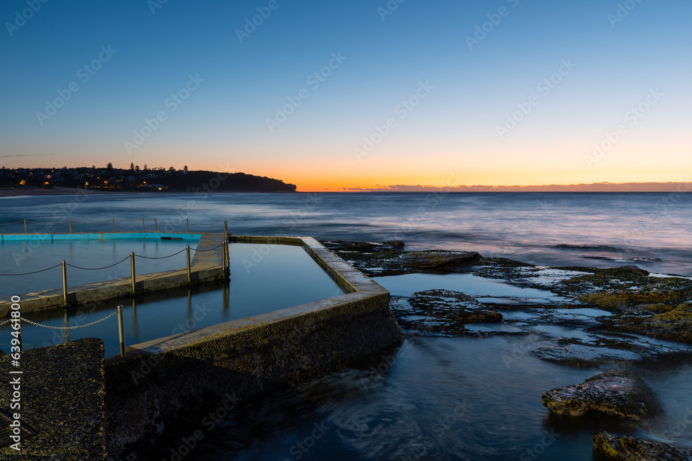 Dawn view of rock pool and rock formation at Curl Curl Beach, Sydney, Australia.