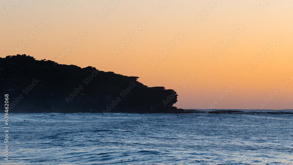 Sunrise view of ocean cliff.