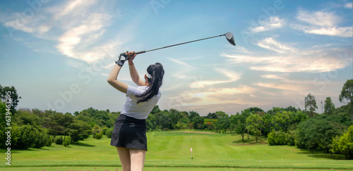 Professional woman golfer teeing to hole in player tournament competition at golf course for winner with green golf background