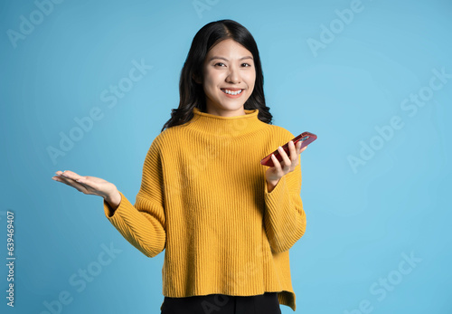 image of young asian girl using phone on a blue background