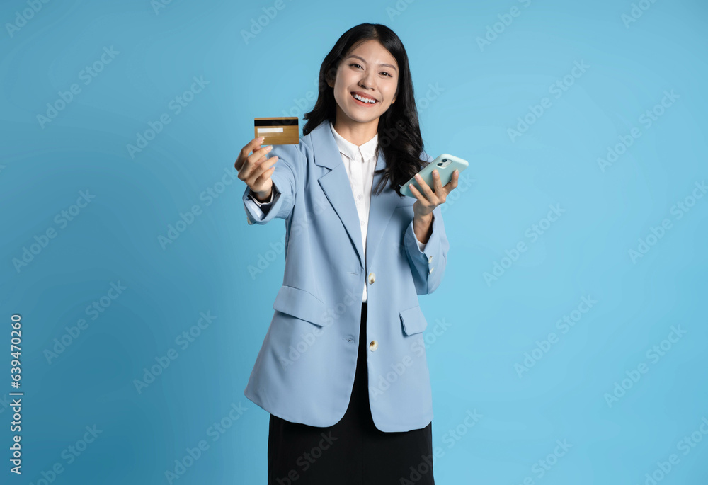 image of asian businesswoman holding a bank card on a blue background image of asian businesswoman holding a bank card on a blue background