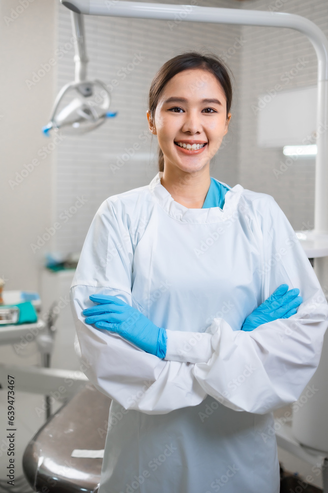 Young asian female dentist looking at camera in dental office.Close up potrait of the doctor woman at white clinic. Young asian female dentist looking at camera in dental office.Close up potrait of the doctor woman at white clinic.
