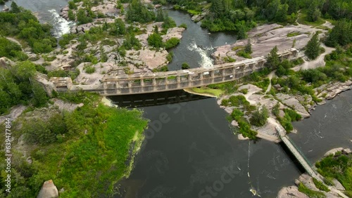 Aerial shot drone descends while the camera pans up at the Pinawa Dam photo