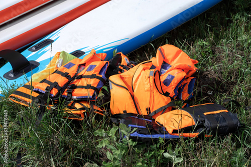 Life jackets lie near SUP boards. Surfing lifestyle concept. © sergofan2015