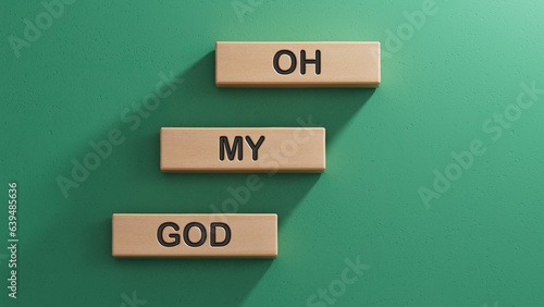 OMG oh my god symbol. Concept words OMG oh my god on wooden blocks. Businessman hand. Business and OMG oh my god concept. Copy space.3D rendering on green background.
