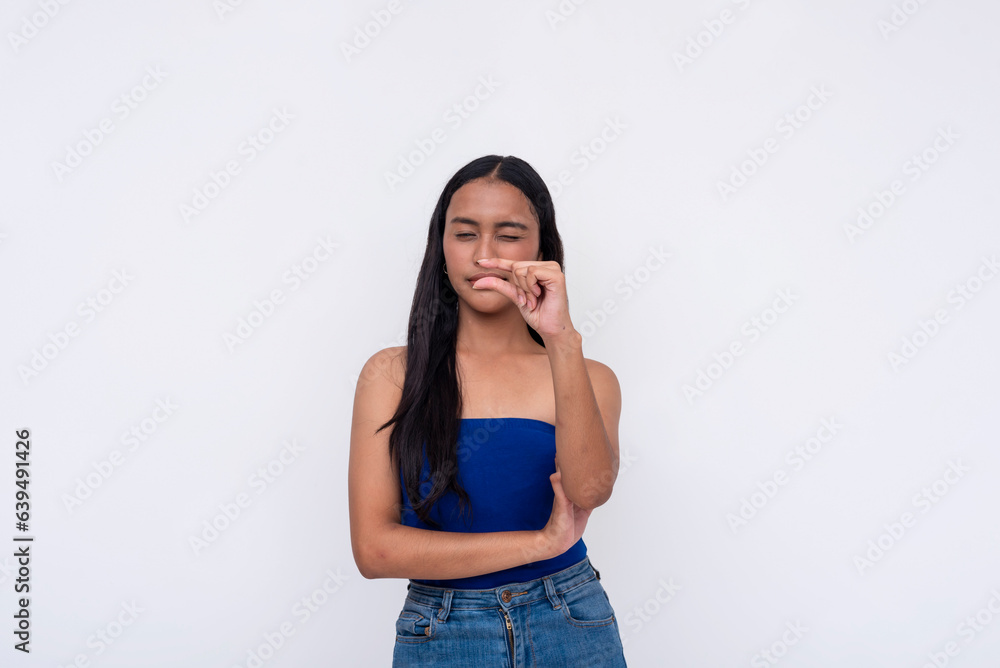 A young Filipino woman expressing something tiny with her fingers. Isolated on a white background. A young Filipino woman expressing something tiny with her fingers. Isolated on a white background.