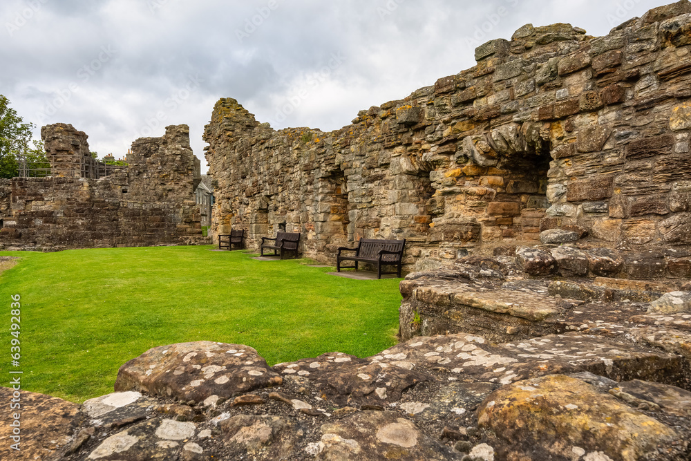 Ruins of Saint Andrews Castle in Scotland and wooden benches to sit and enjoy the views.