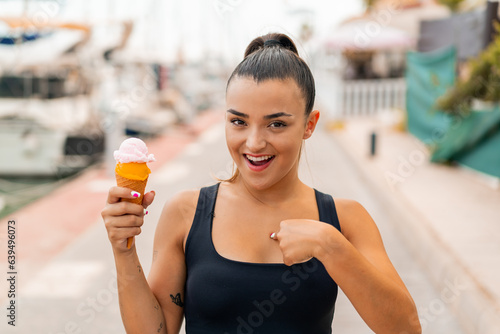 Young pretty woman with a cornet ice cream at outdoors with surprise facial expression