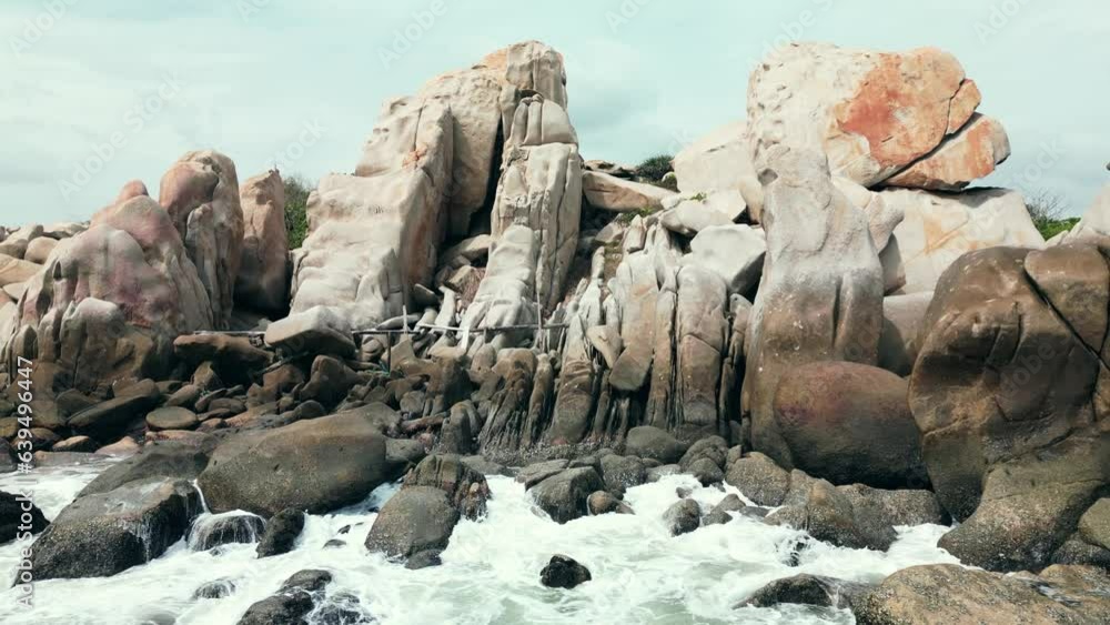 Beautiful rocky rocky shore sticking out sharp small rocks and sea waves. Vietnam Nature. Aerial view footage taken by drone of ocean blue waves crashing against rocks and rocky spikes. 4K. Beautiful rocky rocky shore sticking out sharp small rocks and sea waves. Vietnam Nature. Aerial view footage taken by drone of ocean blue waves crashing against rocks and rocky spikes. 4K.