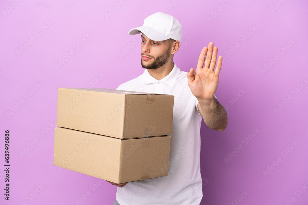 Delivery caucasian man isolated on purple background making stop gesture and disappointed Delivery caucasian man isolated on purple background making stop gesture and disappointed