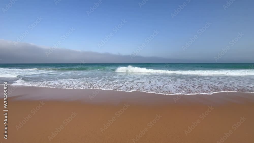 Small waves on sandy beach in golden hour. Summer holidays at the beach. Blue sea and fine sand beach. Small waves on sandy beach in golden hour. Summer holidays at the beach. Blue sea and fine sand beach.