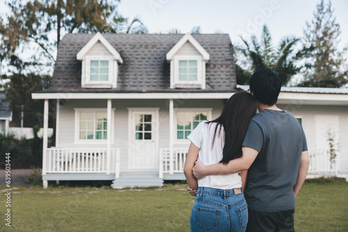 Asian love couple standing outside the new tiny house in countryside © Peera