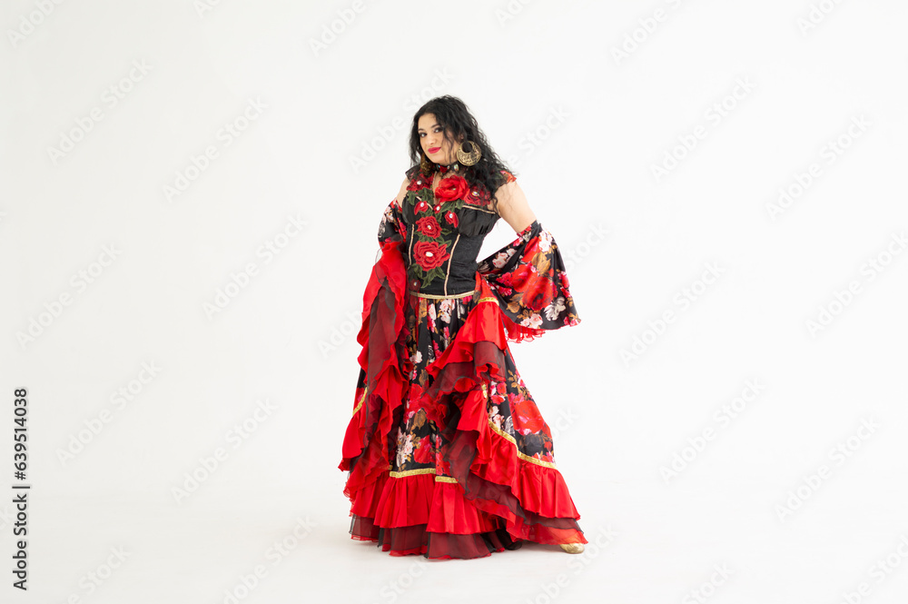 A young girl demonstrates a smart elegant red dress. Flamenco clothing. Gypsy romale style. Professional dancer isolated on white background. A young girl demonstrates a smart elegant red dress. Flamenco clothing. Gypsy romale style. Professional dancer isolated on white background.