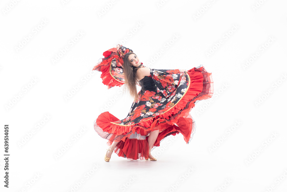A young girl demonstrates a smart elegant red dress. Flamenco clothing. Gypsy romale style. Professional dancer isolated on white background.