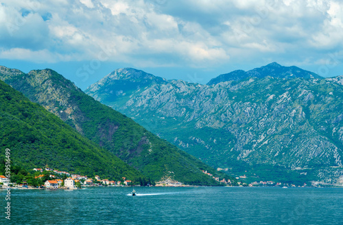 seascapes, a view of the Bay of Kotor during a cruise on a ship in Montenegro, a bright sunny day, mountains and small towns on the coast, the concept of a summer trip