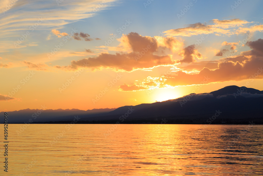 Colorful sea beach over mountains sunrise with deep blue sky and sunbeams. natural background Colorful sea beach over mountains sunrise with deep blue sky and sunbeams. natural background