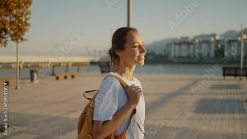 young happy Woman traveler walking bay sidewalk and watching sunset or sunrise with mountains and sea view. Tourism in Turkie, Antalya. active leisure, wanderlust and traveling photo