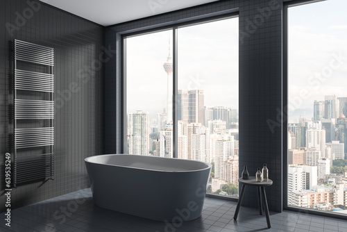 Grey tile home bathroom interior with bathtub and panoramic window