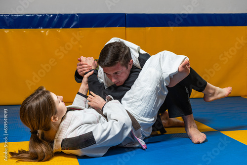 Young girl and boy practice Brazilian jiu jitsu in the gym © Дмитро Петрина