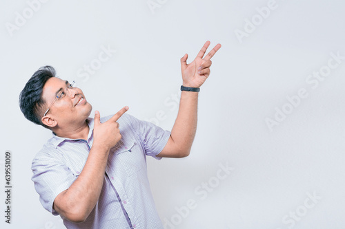 Smiling people pointing a banner to the side. Happy latin man pointing advertisement, smiling man in glasses pointing a space to the side