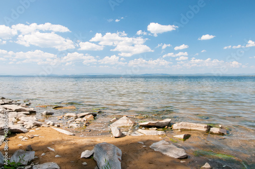 Summer view of Uvildy lake with stones on its sandy shore in the foreground, South Ural, Russia photo