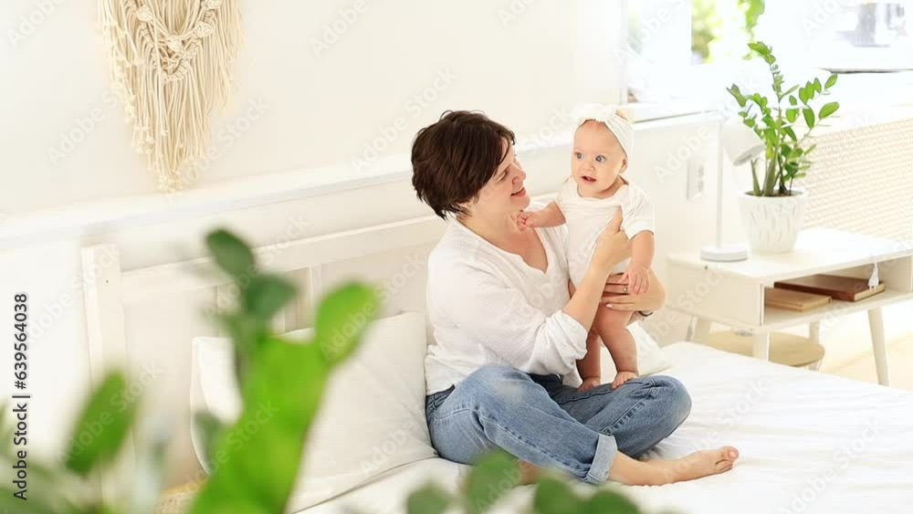 a young mother gently hugs her child kissing and admiring him, a happy family, mom and baby on the bed playing and having fun, maternal love and care, a happy mom on maternity leave a young mother gently hugs her child kissing and admiring him, a happy family, mom and baby on the bed playing and having fun, maternal love and care, a happy mom on maternity leave