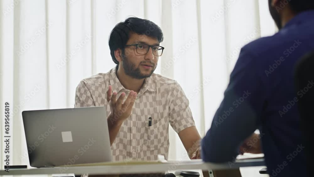 A Modern Young Indian Asian Male Corporate Entrepreneur making an agreement or deal with Business partner followed by a firm Handshake in a startup office Workplace. A Modern Young Indian Asian Male Corporate Entrepreneur making an agreement or deal with Business partner followed by a firm Handshake in a startup office Workplace.