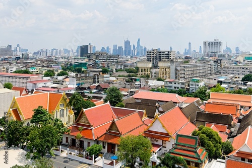Traditional Thai Architecture with Modern Buildings and Skyscrapers in Background and poor area in the middle of the photo.