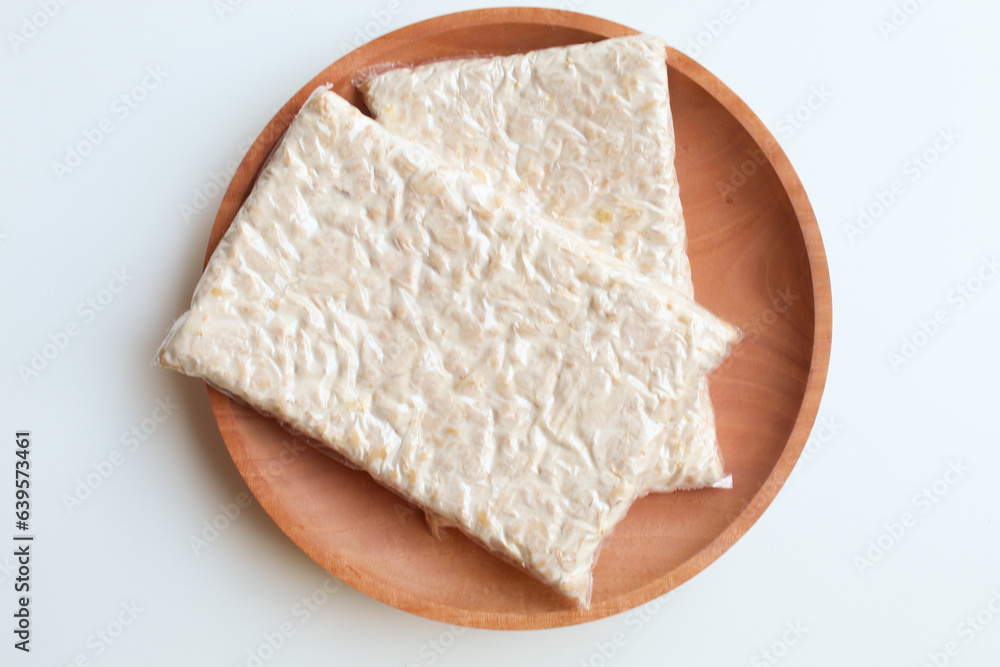 Tempeh or tempe, processed soy product, on wooden background. Isolated on white background. Flat lay or top view Tempeh or tempe, processed soy product, on wooden background. Isolated on white background. Flat lay or top view