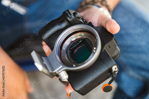 Close up of man hand hold digital camera full frame sensor and lens mount.