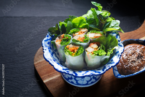 Healthy food concept Homemade vegan Tofu summer rolls or spring roll with peanut dipping sauce on black background with copt space