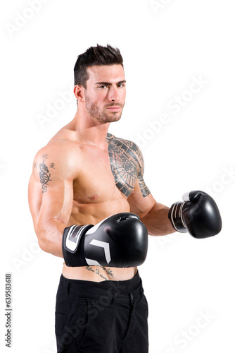 Photo of a muscular man with a tattoo on his arm wearing boxing gloves