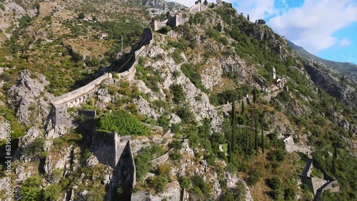 A camera drone flies toward the ancient walls of Kotor Old Town, Montenegro