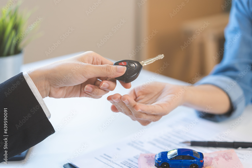 Business car rental company service, Close up hand of agent dealer giving, holding car key to customer renter, new owner after signed rental, purchase contract in document, vehicle sales agreement. Business car rental company service, Close up hand of agent dealer giving, holding car key to customer renter, new owner after signed rental, purchase contract in document, vehicle sales agreement.