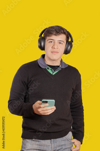 Portrait of a boy with headphones using his mobile phone isolated on white background.