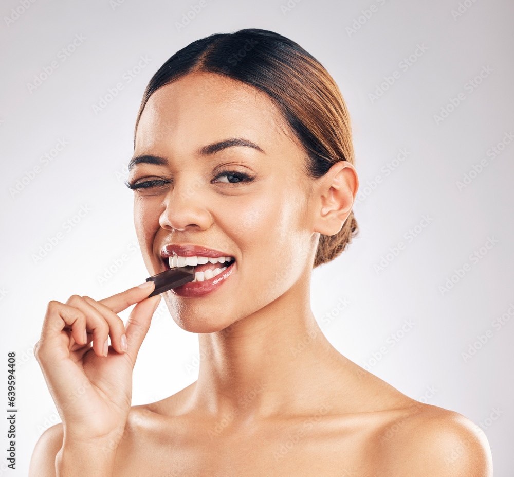 Chocolate, wink and portrait of woman in studio with diet, detox or sweet, unhealthy and snack on white background. Face, emoji and female model with sugar, candy bar or eating isolated cocoa treats Chocolate, wink and portrait of woman in studio with diet, detox or sweet, unhealthy and snack on white background. Face, emoji and female model with sugar, candy bar or eating isolated cocoa treats