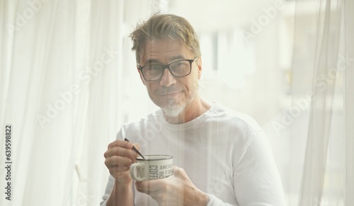 Middle aged man drinking morning coffee at home