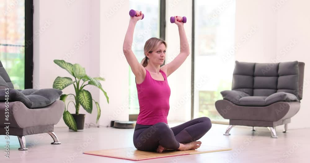 Determined, purposeful woman loses weight at home and trains with small dumbbells. Strong fitness woman doing arm workout with barbell in living room sport and fitness Determined, purposeful woman loses weight at home and trains with small dumbbells. Strong fitness woman doing arm workout with barbell in living room sport and fitness