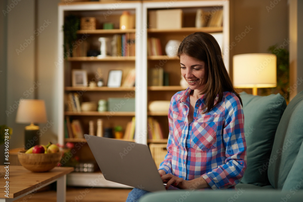 Young smiling woman working remotely from home on laptop Young smiling woman working remotely from home on laptop