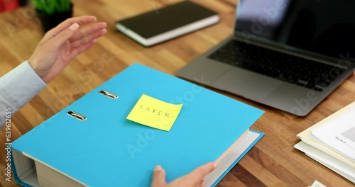 Accountant employee sticks sticker with inscription later on business folder with documents. Deadlines on demand for deferred signing